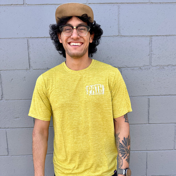 man wearing a patagonia men's capilene cool tee, shrub green perch yellow 